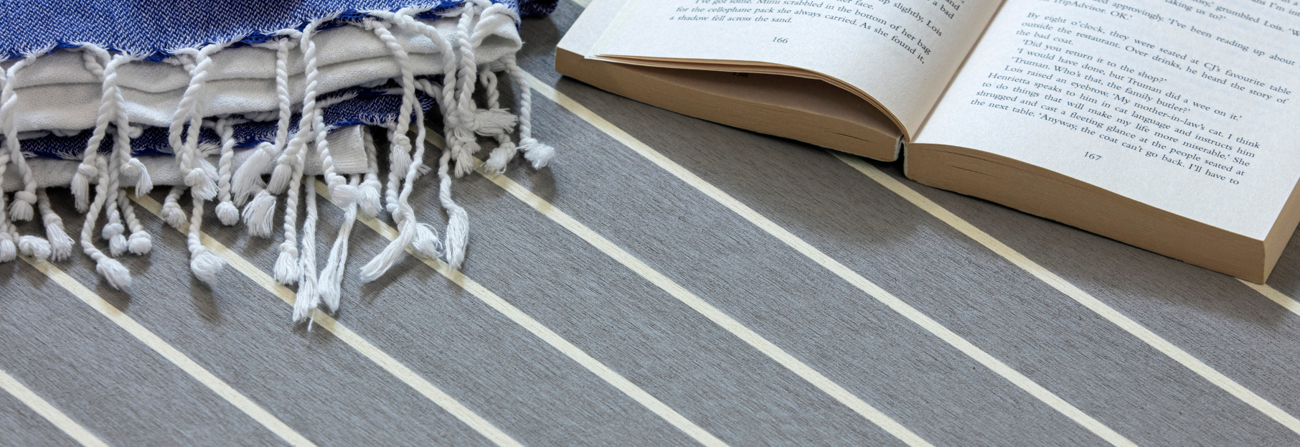 Flexiteek Grey med hvit fugemasse med bok, håndkle og solbriller